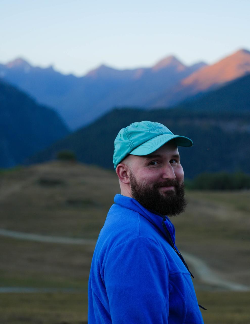 Nikita Solovev, in a cap and blue fleece, with mountains behind him.
